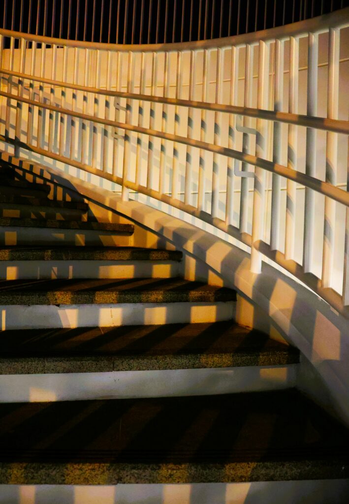 Artistic view of a curved staircase with dramatic shadows in Taiwan, captured at night.